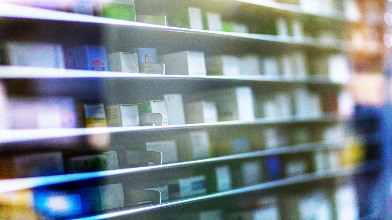 Imagen ligeramente borrosa de medicamentos en el estante de una farmacia