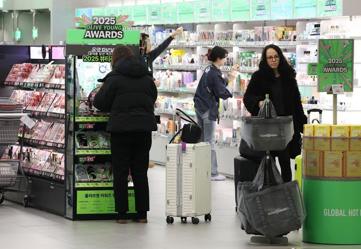 Viajeros extranjeros compran cosméticos en una tienda Olive Young en el Aeropuerto Internacional de Incheon, el 16 de diciembre. Yonhap
