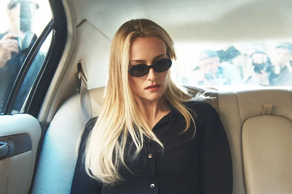 Sarah Pidgeon como Carolyn Bessette-Kennedy se encuentra en un coche de ciudad con gafas de sol en Love Story.