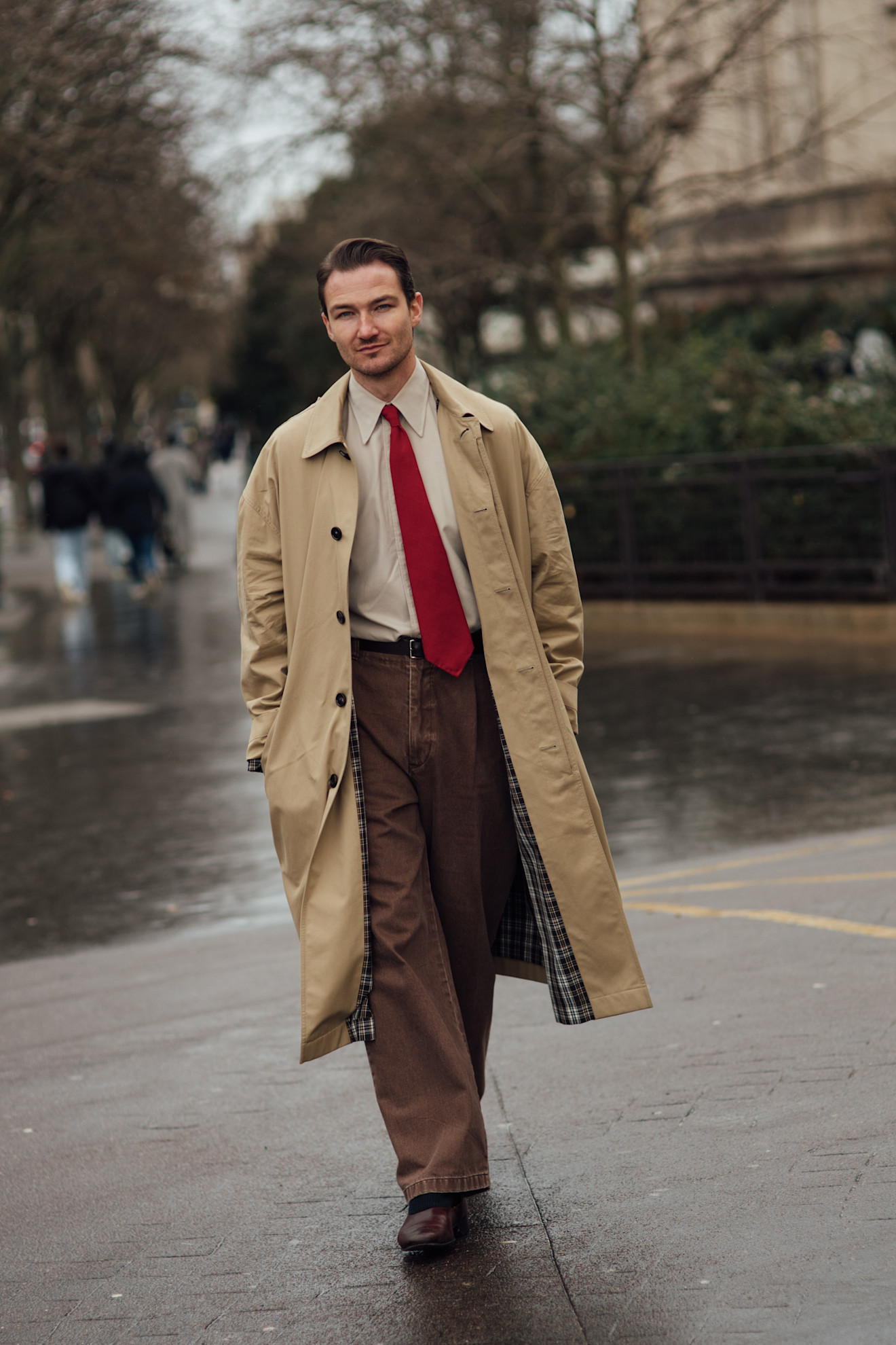 un hombre que lleva una corbata roja al estilo callejero de la semana de la moda masculina