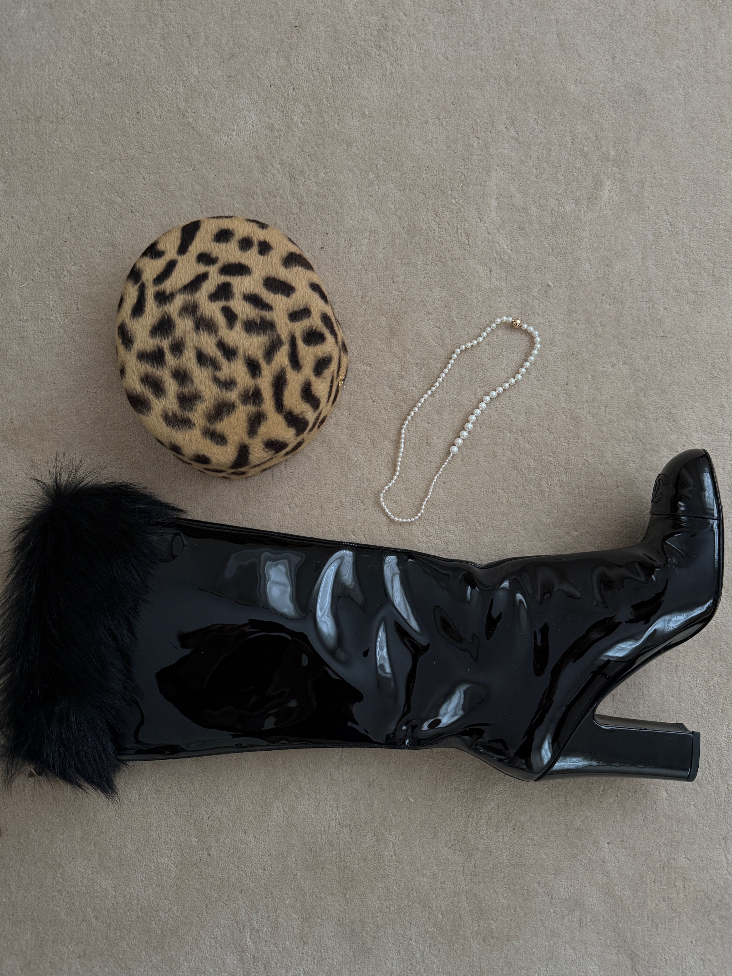 Bota negra y bolso y collar de estampado de leopardo de Christie Tyler en el suelo