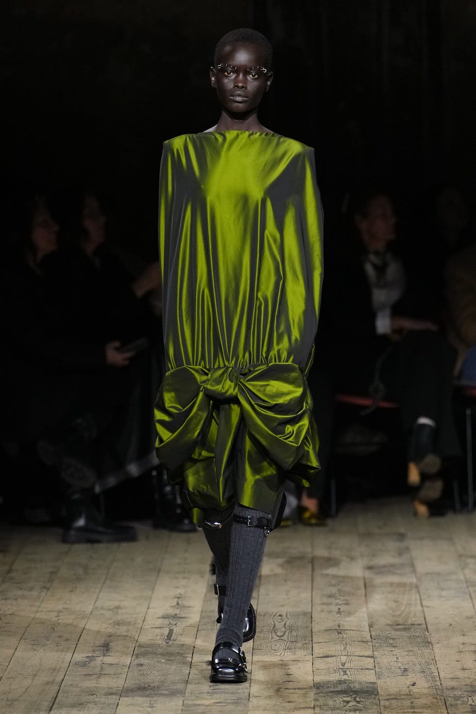 modelo que lleva una pieza verde distintiva en la pasarela modelo que lleva una pieza verde distintiva en la pasarela
