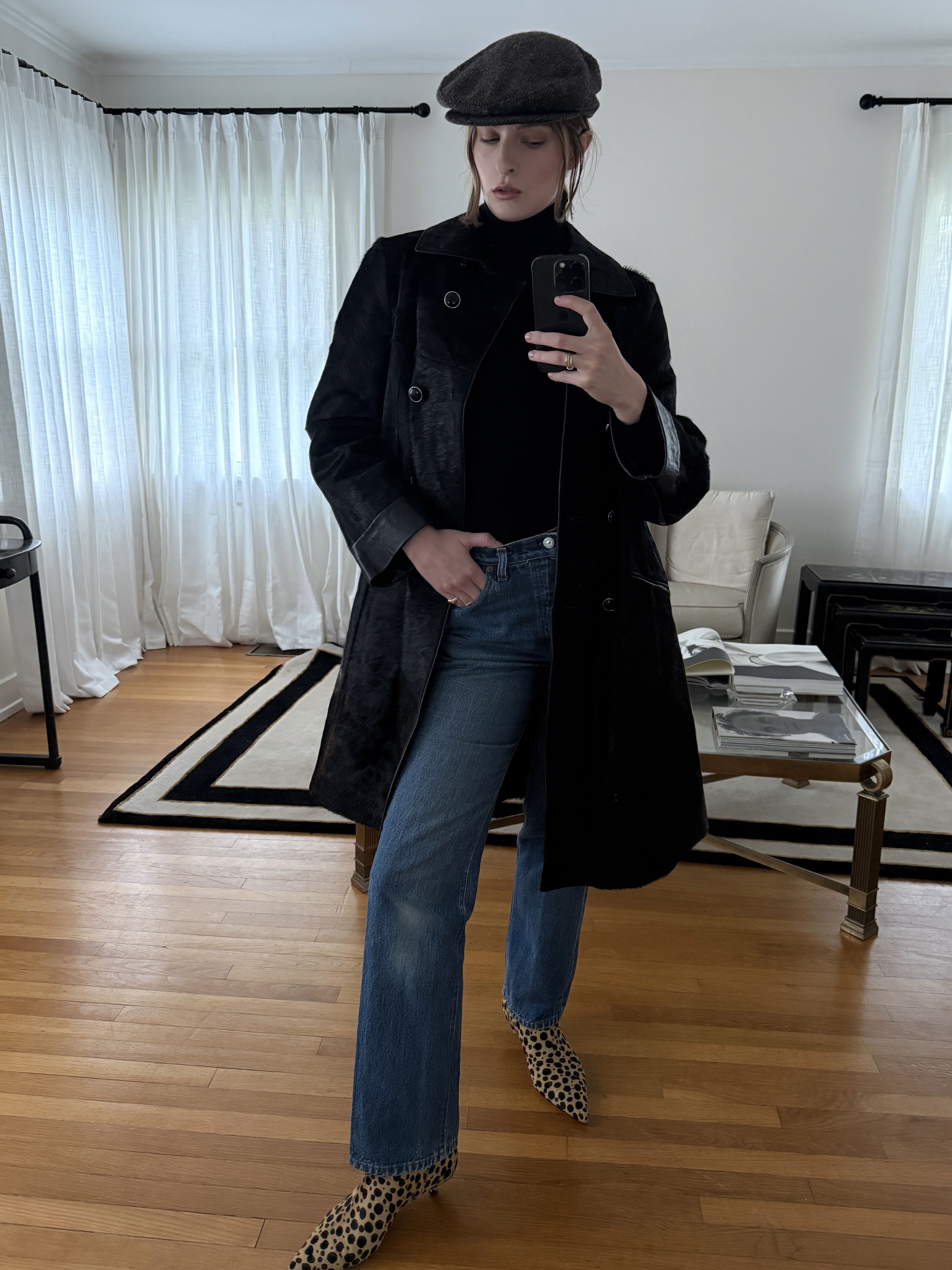 Christie Tyler con una boina negra, una chaqueta negra, vaqueros azules y zapatos con estampado de leopardo
