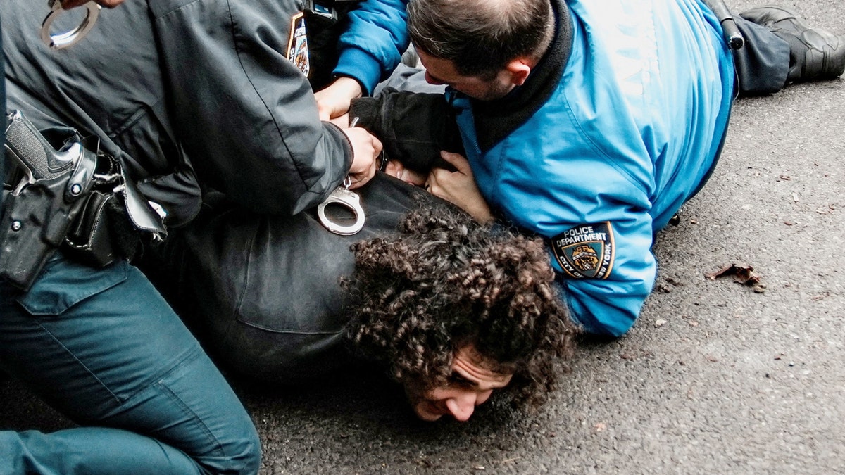 Un hombre en el suelo con agentes de la policía de Nueva York encima