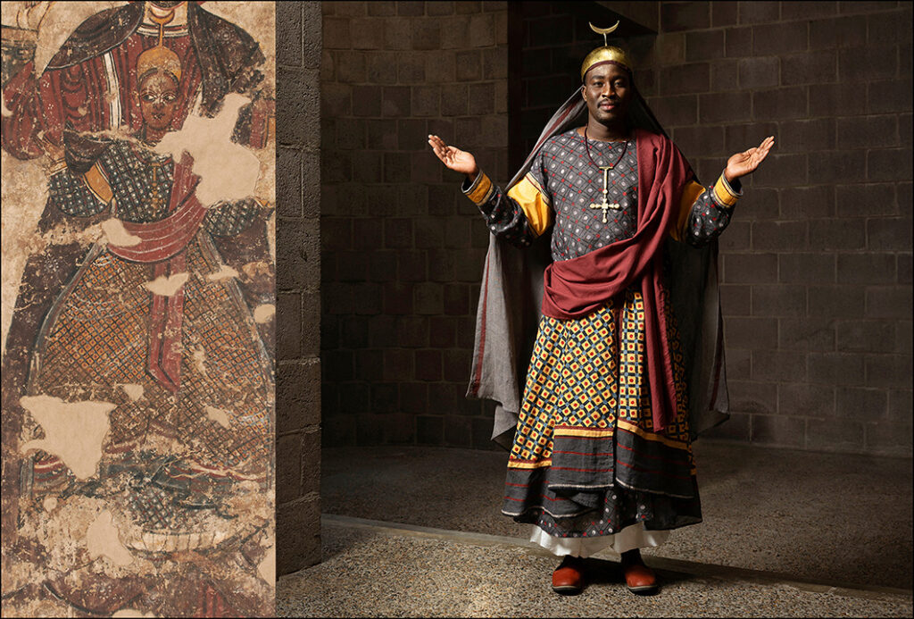 Modelo que lleva la túnica del rey nubios con estampados grises, rojos y blancos, que se muestra junto a la pintura antigua que inspiró la recreación
